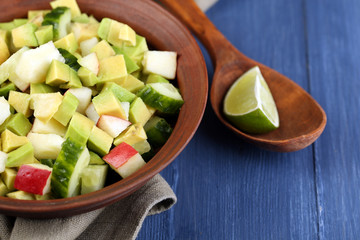 Salad with apple and avocado in bowl with napkin