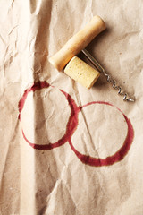 Wine stains, cork and corkscrew on crumpled paper background