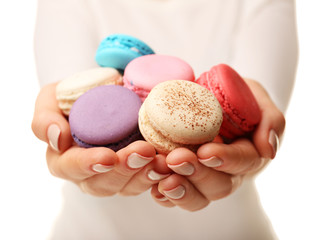 Tasty colorful macaroons in female hands