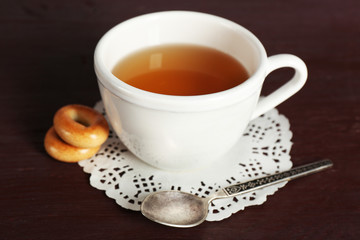 Cup of tea with bagels on color wooden table background
