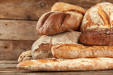 Different fresh bread on old wooden table