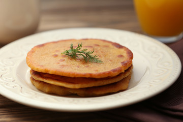 Stack of corn tortillas with stuffing and glass of juice