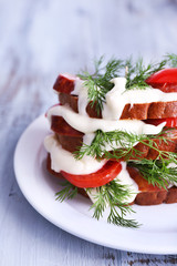 Sandwich with sausage, tomato and mayonnaise on plate, closeup