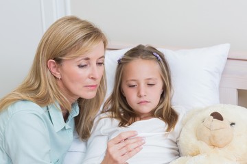 Mother measuring her daughters temperature