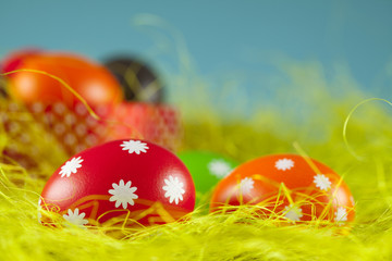 Colored Easter eggs on the grass and blue sky background