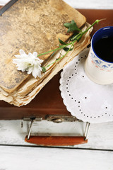 Old wooden suitcase with old books and flowers