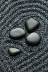 Fototapeta na wymiar Zen garden with a silk black stones with wave patterns in the sa