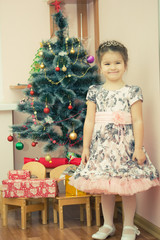 pretty little girl near the new year tree. beautiful girl in dress near Christmas tree waiting for holiday. little Princess