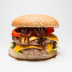 Double hamburger with red onion, tomatoes, cheese and salad