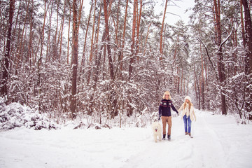 Fototapeta na wymiar boy and girl holding hands, winter walks in the woods