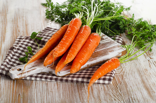 carrots with green leaves on a wooden table