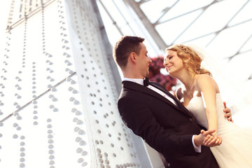 groom and bride outdoors on a metalic construction