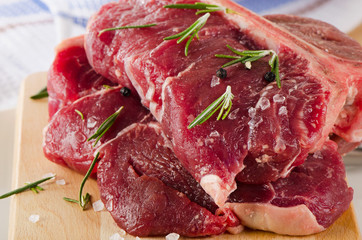 Raw T-Bone Steak with Seasoning  on a wooden board.