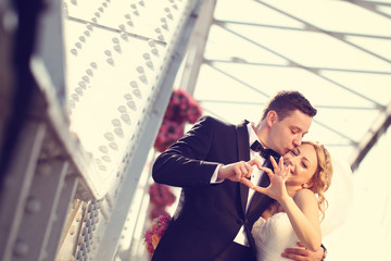 groom and bride doing love sign with their hands