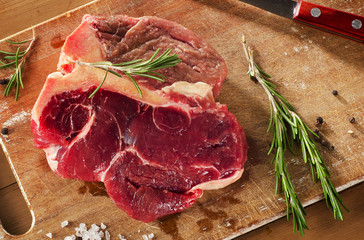 Raw Steak with Seasoning and fresh herbs on  wooden board.