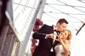 groom and bride doing love sign with their hands