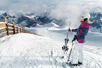 Fotobehang Young female skier admiring the stunning view © Aenyeth