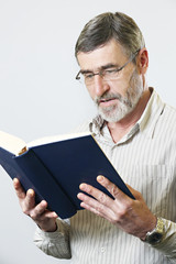 Middle aged bearded man reading a book