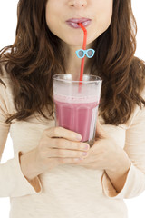 Woman drinking berry smoothie from a big smoothie glass