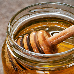 Honey and dipper closeup detail. Healthy food, sweetener.