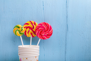 cups and lollipop on the blue wooden background