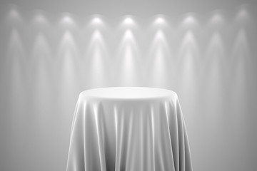 Round pedestal with white silk cloth and spot lights