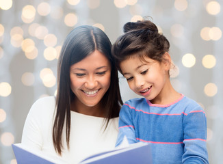 happy mother and daughter reading book