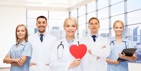 happy young doctors cardiologists with red heart