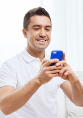 happy man with smartphone at home