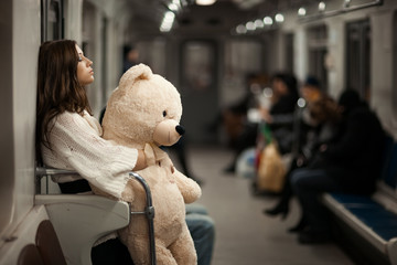 Girl with bear in a subway car.