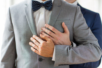 close up of male gay couple with wedding rings on