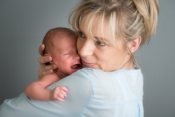 portrait of a newborn baby boy in his mother's shoulder