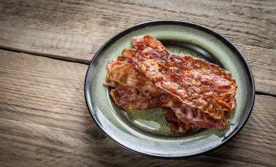 Stack of fried bacon strips on the plate