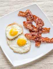 Portion of fried eggs with bacon