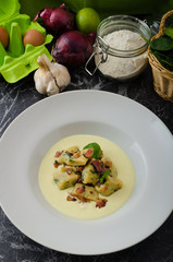 Spinach gnocchi with parmesan sauce topped with bacon