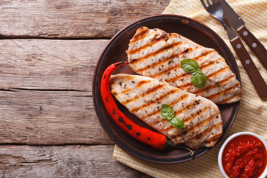 Grilled chicken fillet and chili on a plate horizontal top view