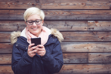 Young Woman looking into her Smartphone and smiling