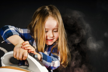 Cute little girl helping your mother by ironing clothes, contras