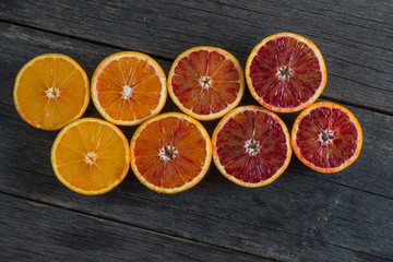 different shadows of orange fruit on wooden background