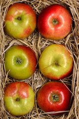 Fresh apples in box on wooden table close-up