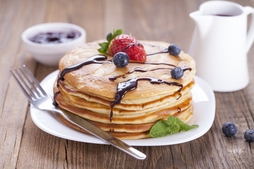 Delicious sweet American pancakes on a plate with fresh fruits