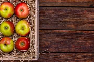 Fresh apples in box on wooden table with copy space