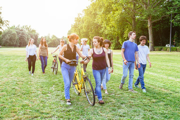 Obraz premium Group of teenagers at the park at sunset in a summer day