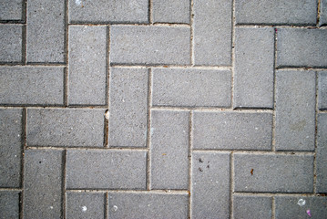 Textured background of grey bricks in a herringbone pattern
