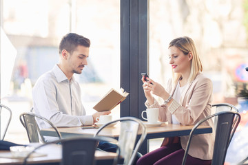 Two young business people on a coffee break in a restaurant.