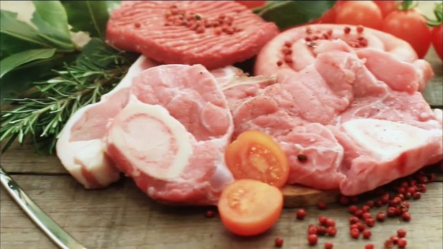 raw meat selection with herbs over wood