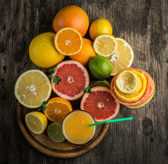 Naklejka na ściany i meble Citrus juice and fruits on vintage wooden background