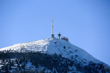 Fototapeta na wymiar Le puy de dome, Paysages d'hiver en auvergne. Antenne sur Montagne avec neige, sapins et ciel bleu.