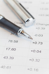 Close - up Pen and stock market data chart . .