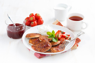 Delicious pancakes with fresh strawberries on a plate, jam